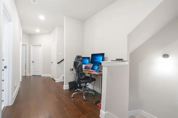 a view of a workspace with furniture and a wooden floor