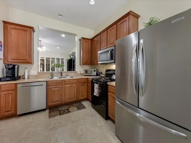 a kitchen with stainless steel appliances a refrigerator sink and microwave