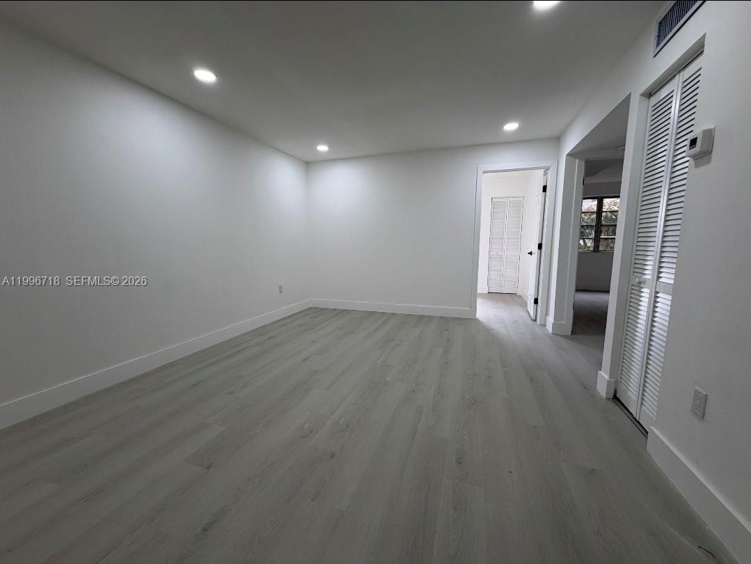 300 West 74th Place, Unit 217 Hialeah, FL 33014 - Photo 4 of 8 an empty room with wooden floor and windows