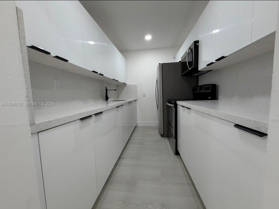 300 West 74th Place, Unit 217 Hialeah, FL 33014 - Photo 5 of 8 a kitchen with stainless steel appliances a refrigerator and a stove