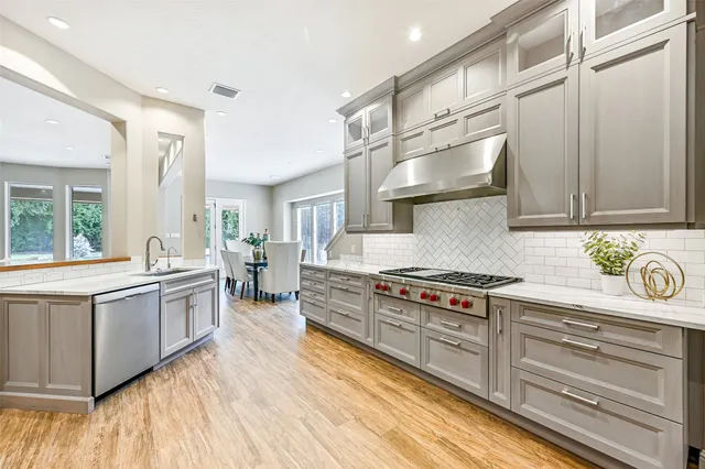 a kitchen with stainless steel appliances a stove a refrigerator and cabinets
