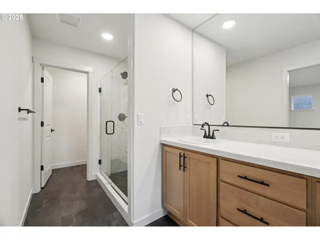 a bathroom with a double vanity sink a mirror and a shower