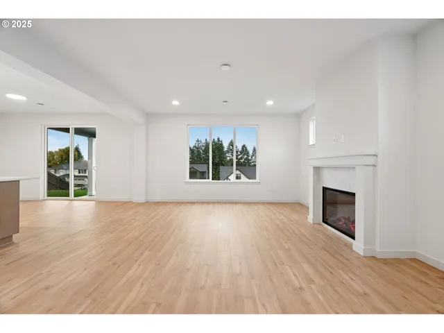 a view of an empty room with a window and fireplace