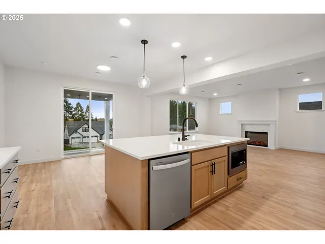 a kitchen with a sink and wooden floor
