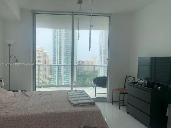 a bedroom with a bed and a lamp next to a window