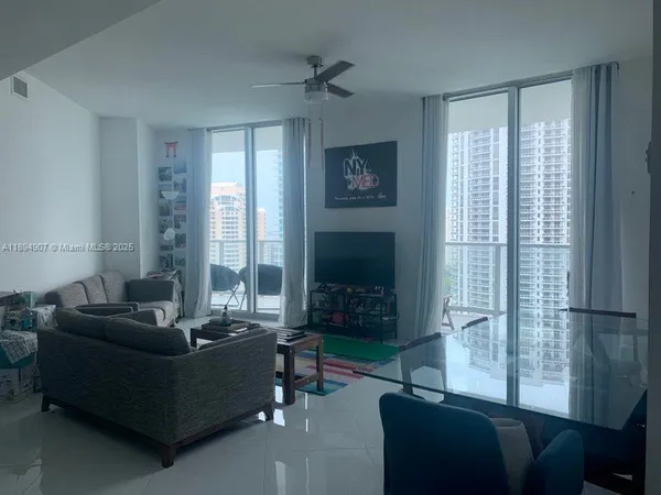a living room with furniture a flat screen tv and a window