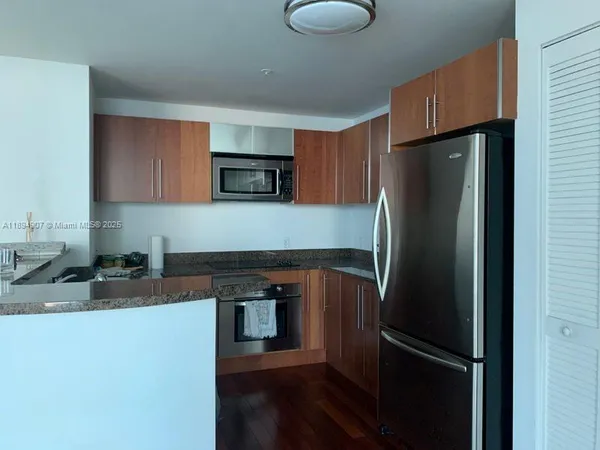 a kitchen with granite countertop a refrigerator and a sink