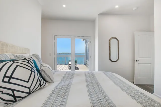 a spacious bedroom with a bed and a large mirror