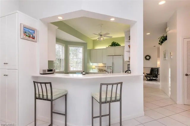 a kitchen with a dining table chairs cabinets and stainless steel appliances