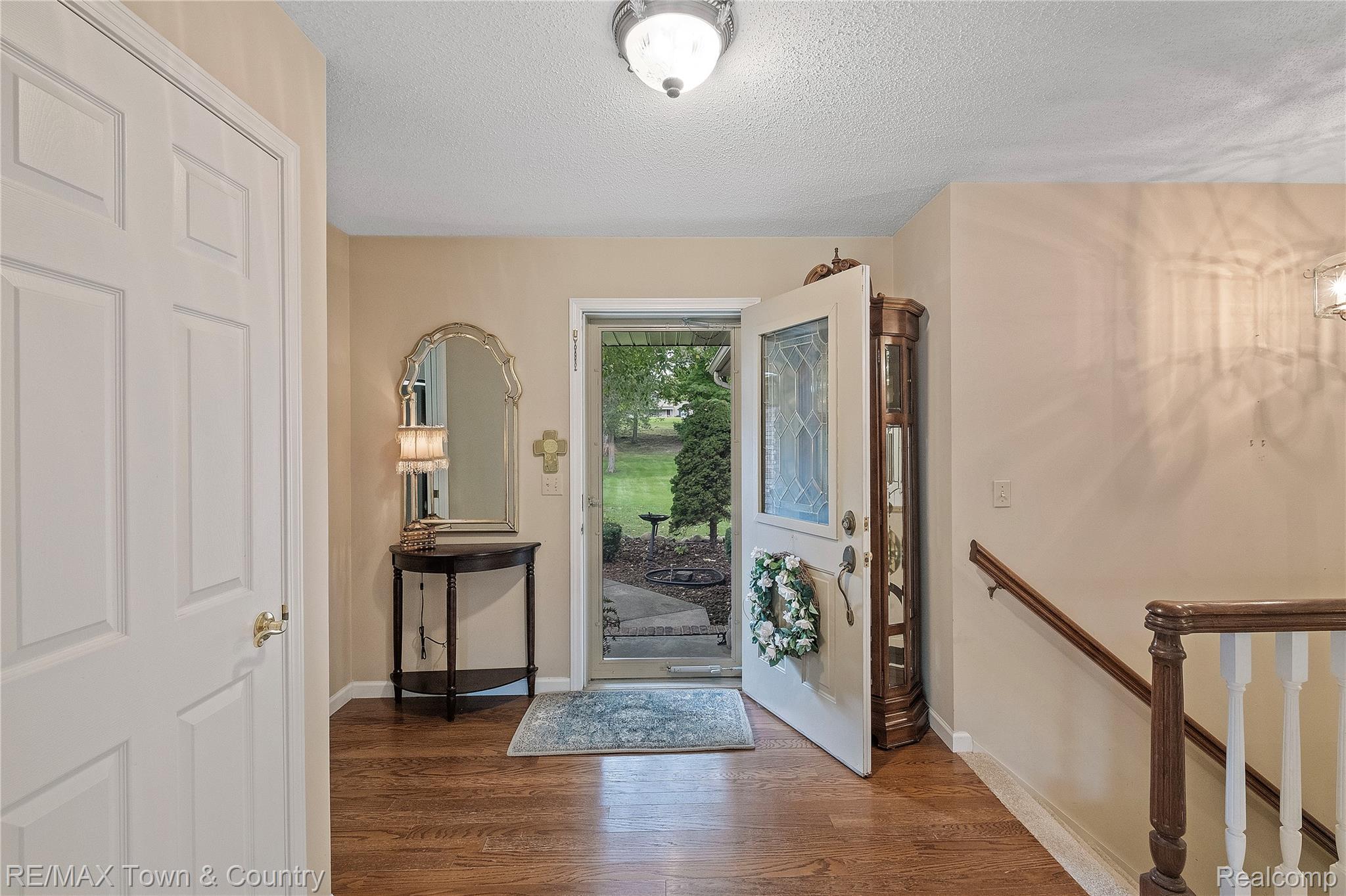 5464 North Seymour Road Flushing, MI 48433 - Photo 7 of 45 Wood-finish flooring throughout, white paneled interior door, and a white front door with decorative glass inserts