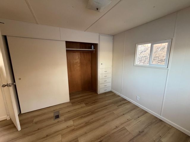 an empty room with wooden floor and entrance