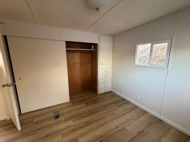 an empty room with wooden floor and entrance