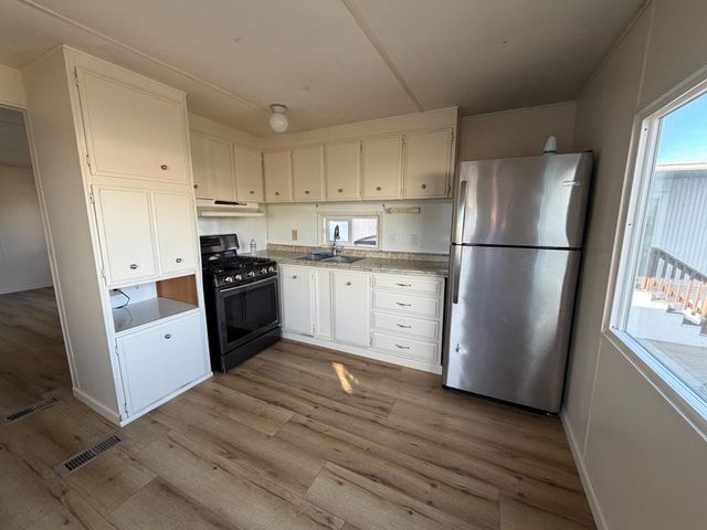 a kitchen with white cabinets stainless steel appliances and a refrigerator