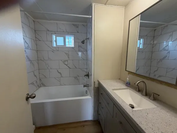 a bathroom with a tub sink and mirror