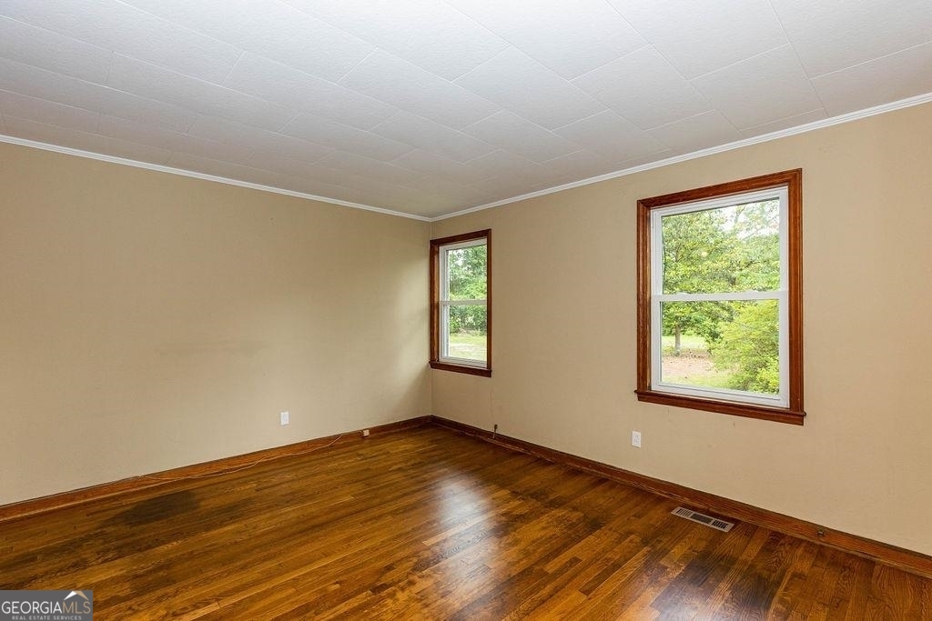 405 Springfield Avenue Guyton, GA 31312 - Photo 15 of 39 a view of an empty room with wooden floor and a window