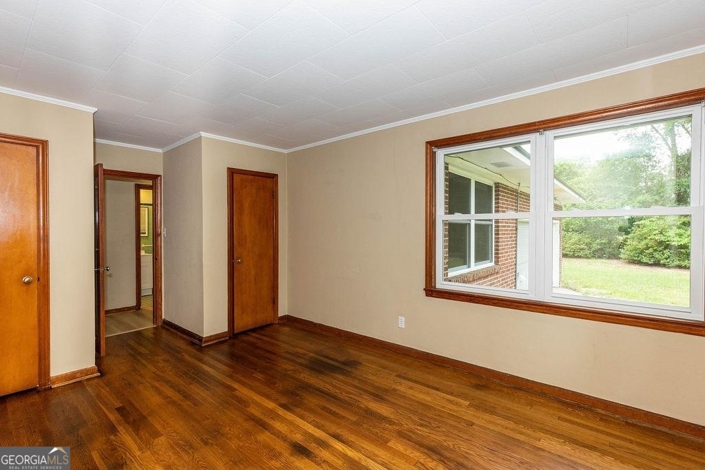 405 Springfield Avenue Guyton, GA 31312 - Photo 20 of 39 an empty room with wooden floor and windows