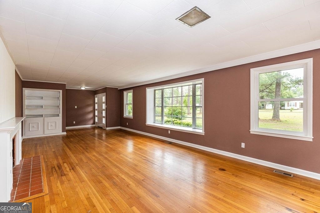 405 Springfield Avenue Guyton, GA 31312 - Photo 2 of 39 wooden floor in an empty room with a window