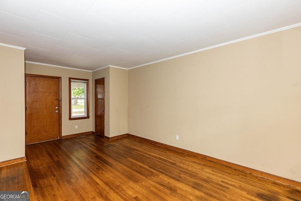 405 Springfield Avenue Guyton, GA 31312 - Photo 22 of 39 a view of an empty room with wooden floor and a window