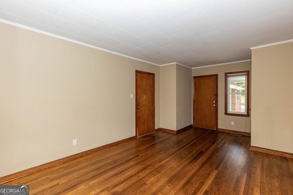 405 Springfield Avenue Guyton, GA 31312 - Photo 23 of 39 a view of an empty room with wooden floor and a window