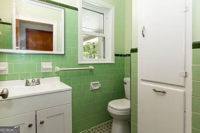 a bathroom with a sink mirror toilet and vanity