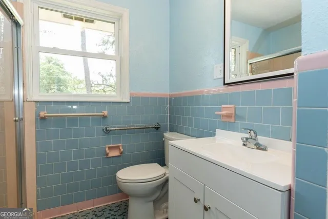 a bathroom with a sink a toilet and a mirror