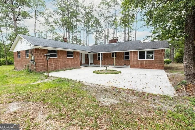 a front view of a house with a yard and trees