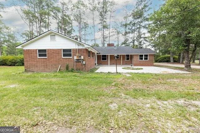 a front of a house with yard and green space