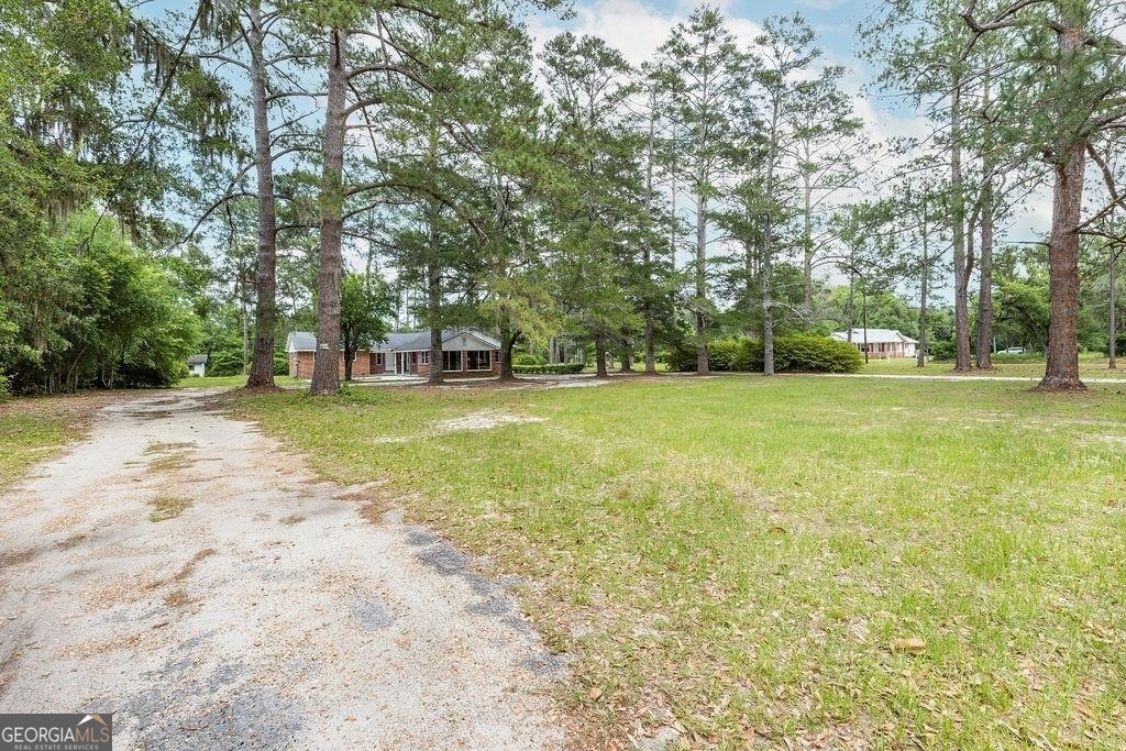 405 Springfield Avenue Guyton, GA 31312 - Photo 34 of 39 a view of a green field with trees in the background
