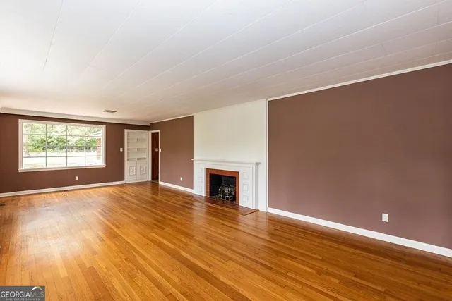 wooden floor fireplace and windows in an empty room