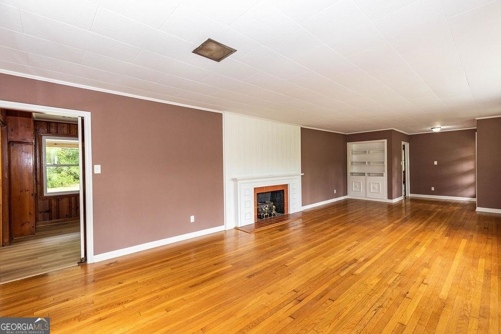 405 Springfield Avenue Guyton, GA 31312 - Photo 5 of 39 a view of empty room with wooden floor and fan
