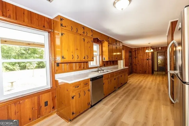 a large kitchen with stainless steel appliances a large counter top