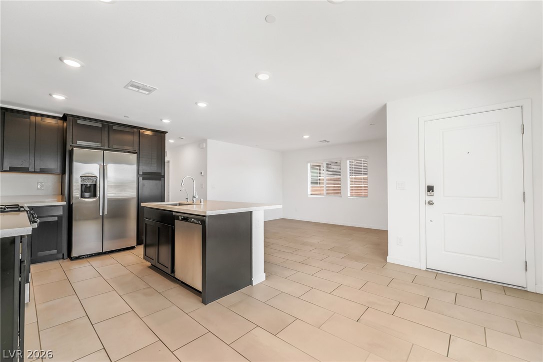 894 Cadence View Way Henderson, NV 89011 - Photo 8 of 23 A contemporary kitchen and living area featuring sleek cabinetry, stainless steel appliances, and durable tile flooring.