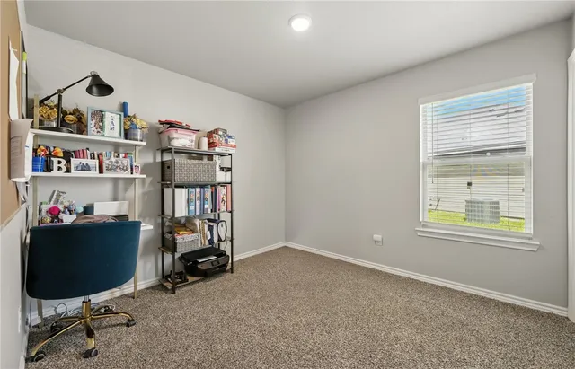 a view of a workspace with furniture and a window