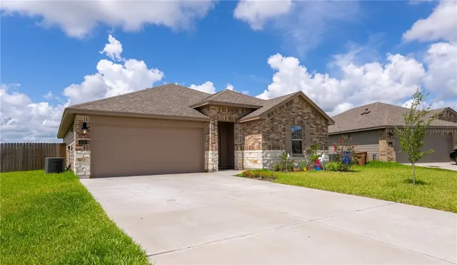 a front view of a house with a yard and garage