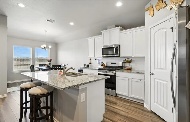 a kitchen with appliances a sink and cabinets