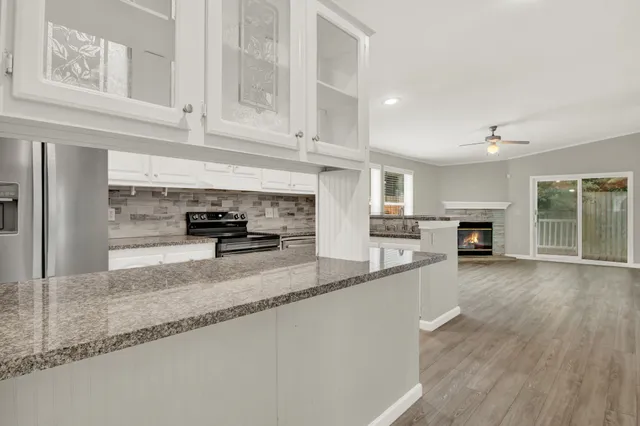 a kitchen with granite countertop a stove a sink and a refrigerator