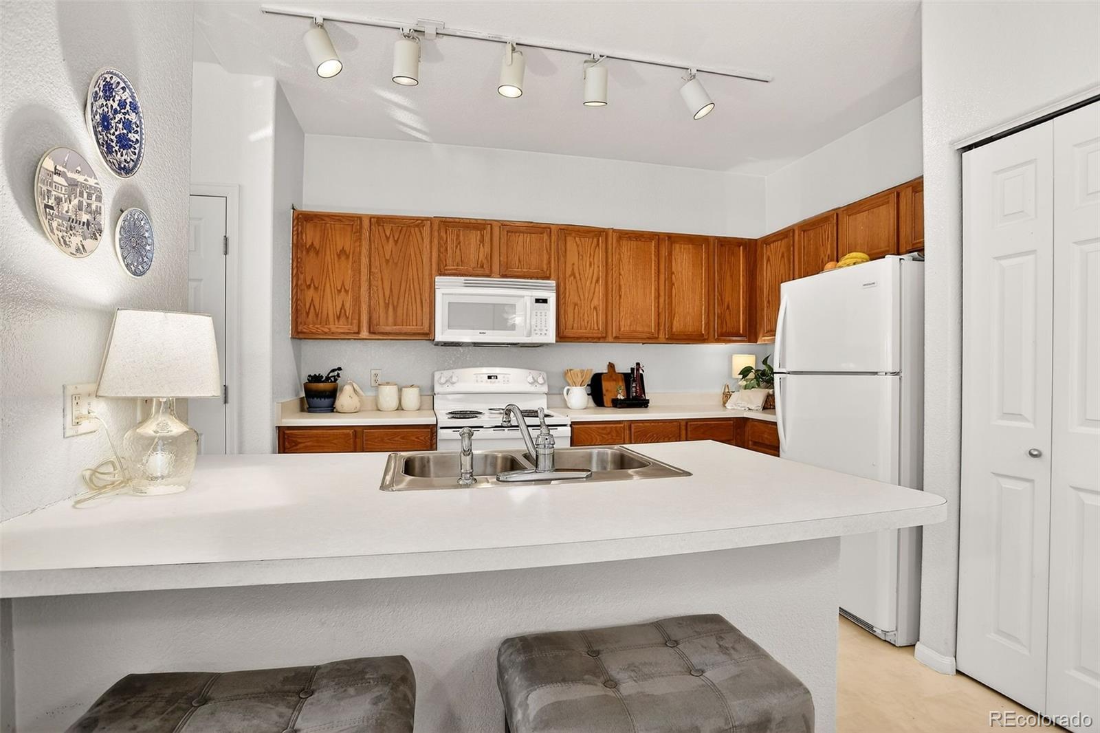 10715 Twenty Mile Road, Unit 202 Parker, CO 80134 - Photo 11 of 26 a kitchen with refrigerator and white cabinets