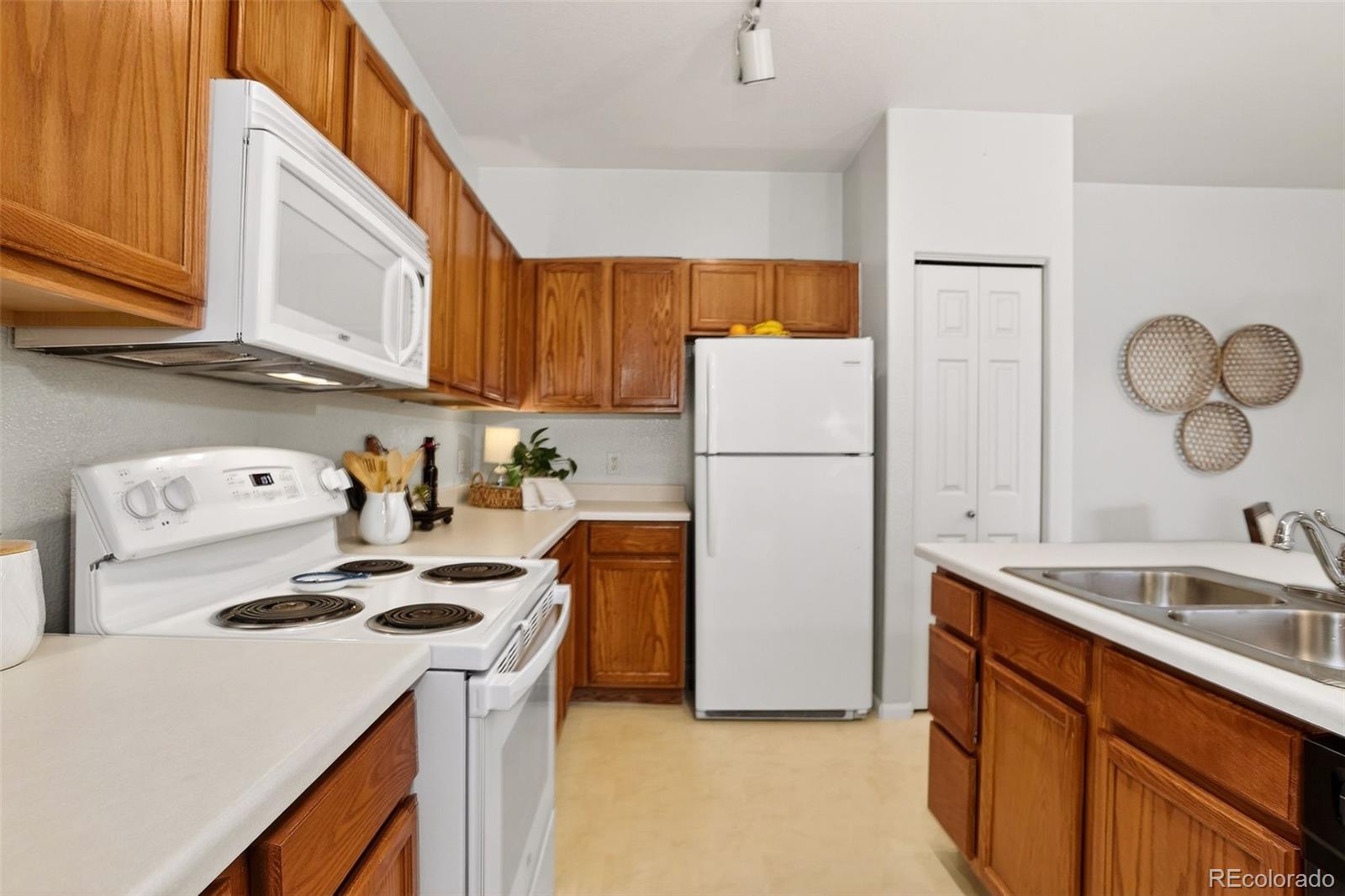 10715 Twenty Mile Road, Unit 202 Parker, CO 80134 - Photo 14 of 26 a kitchen with a refrigerator a stove a sink and cabinets