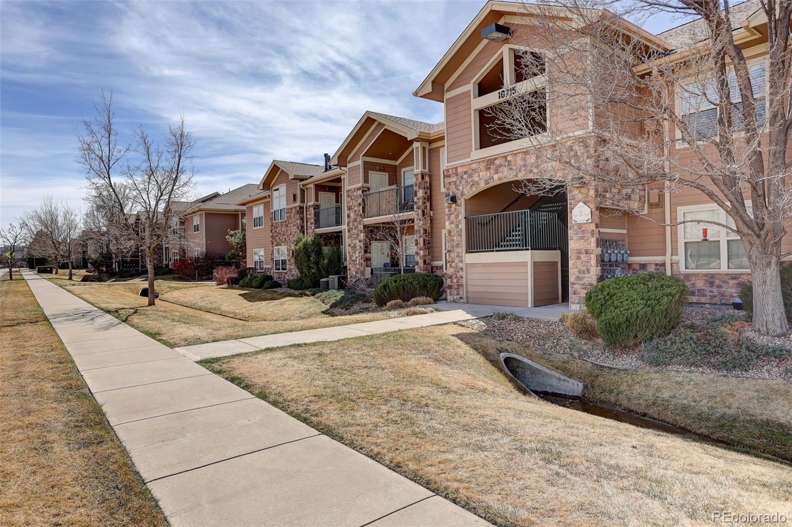 10715 Twenty Mile Road, Unit 202 Parker, CO 80134 - Photo 3 of 26 a front view of a house with a yard