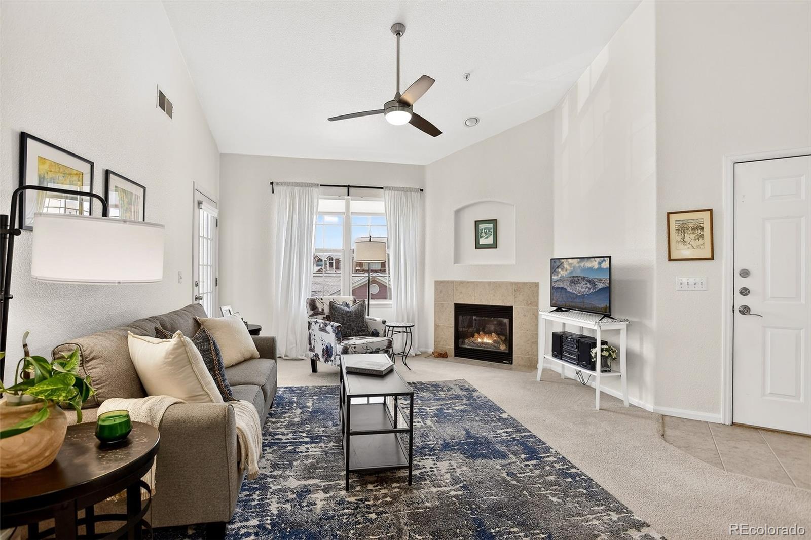 10715 Twenty Mile Road, Unit 202 Parker, CO 80134 - Photo 5 of 26 a living room with furniture a fireplace and a table