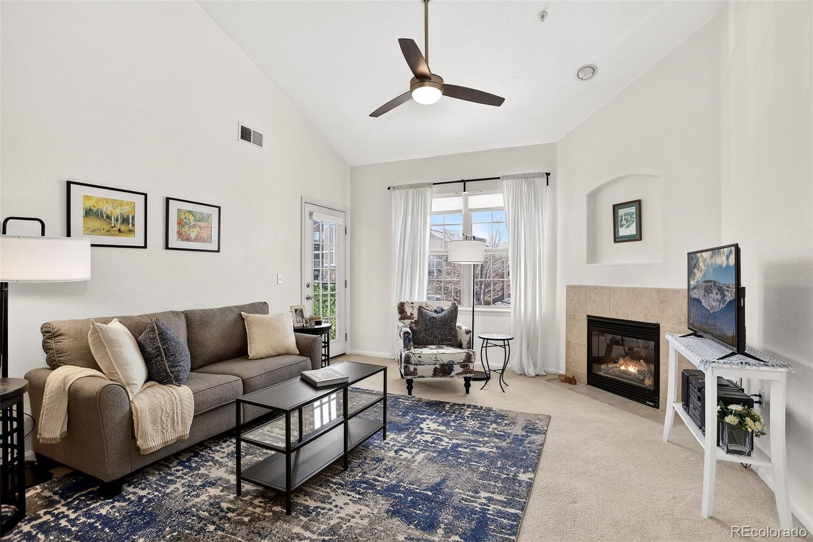 10715 Twenty Mile Road, Unit 202 Parker, CO 80134 - Photo 6 of 26 a living room with furniture a window and a fireplace
