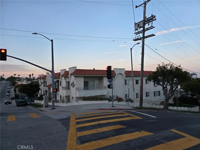 a view of building with cars parked in front of it