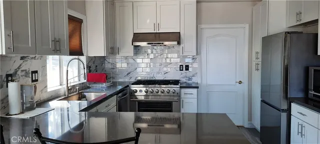 a kitchen with stainless steel appliances granite countertop a stove and a refrigerator
