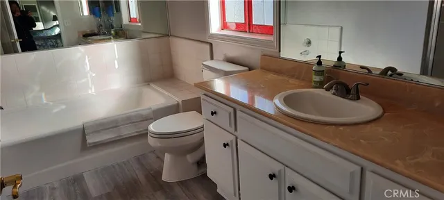 a bathroom with a granite countertop sink a toilet and a mirror