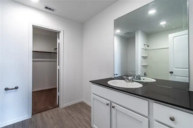 a bathroom with a granite countertop sink and a mirror