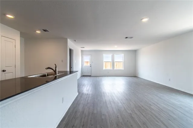 a view of a big room with wooden floor and windows