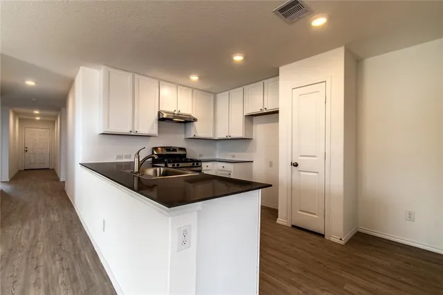 a kitchen with a sink stove and refrigerator