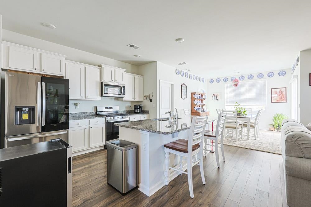 2115 Ridgedale Drive Conway, SC 29526 - Photo 6 of 38 Kitchen featuring stainless steel appliances, dark stone countertops, white cabinetry, and dark wood-style floors
