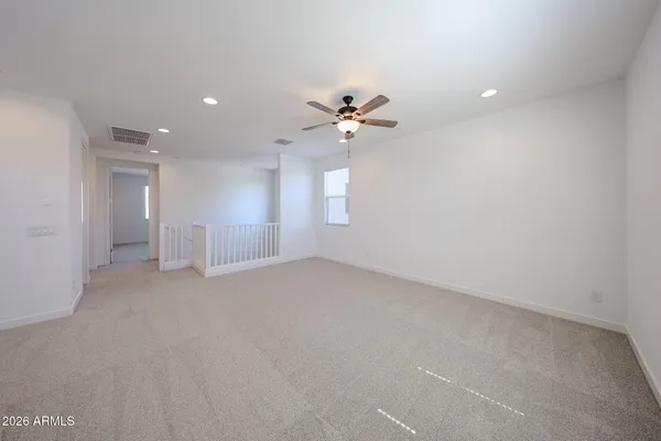 a view of an empty room with a ceiling fan