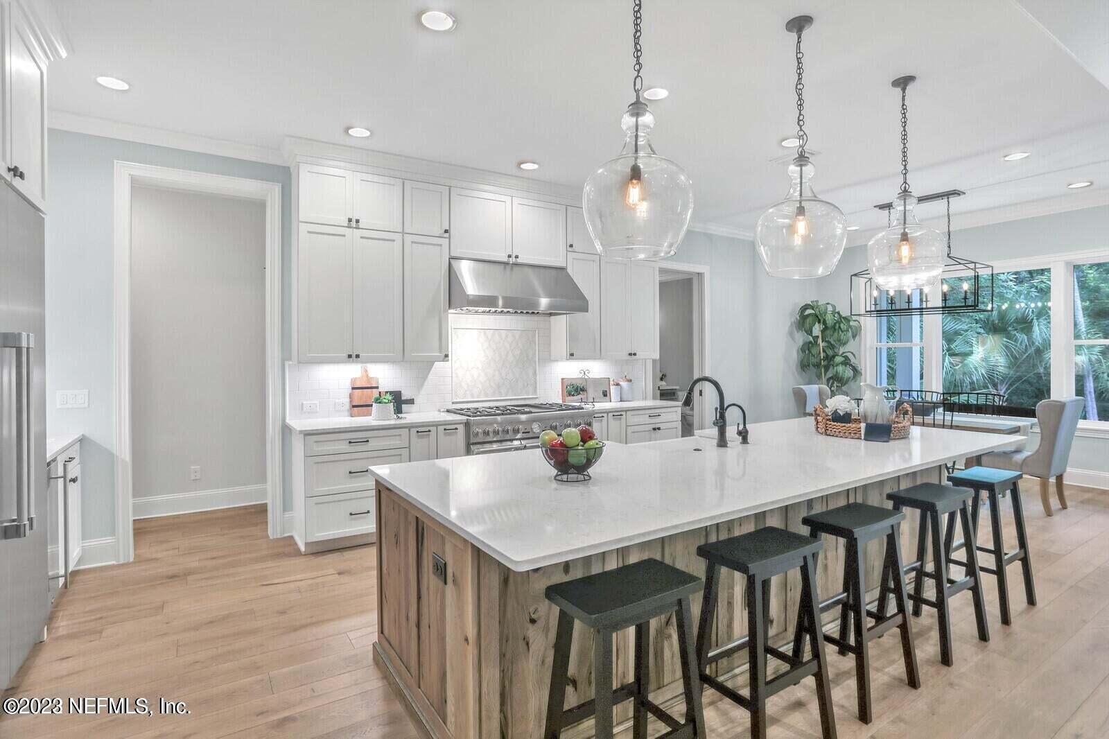 168 Hickory Hill Drive St. Augustine, FL 32095 - Photo 12 of 42 a kitchen with granite countertop a table chairs stove a refrigerator and cabinets